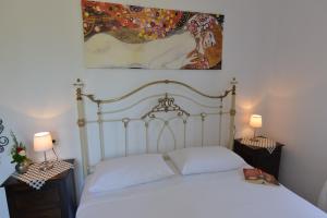 a bedroom with a white bed and a painting on the wall at Haus Katerina in Vourvourou