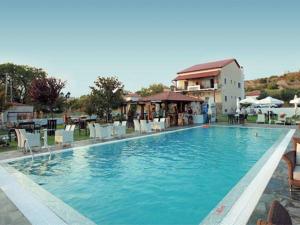 una gran piscina con sillas y un edificio en Agnanti en Ávdhira