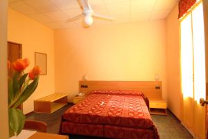 una camera con un letto con copriletto rosso di Hotel San Geminiano a Modena