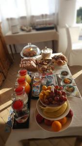 a table topped with plates of food and fruit at Hotel Santa Marina Antica Foresteria in Santa Marina Salina