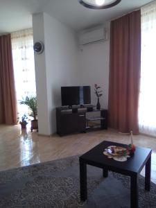 a living room with a tv and a coffee table at GENIKO Apartments in Pomorie