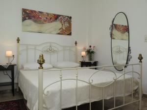 a bedroom with a white bed and a mirror at Haus Katerina in Vourvourou