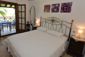 a bedroom with a white bed and a table with a surfboard at Haus Katerina in Vourvourou