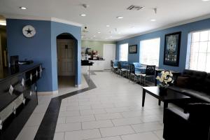 a waiting room with blue walls and tables and chairs at Ranger Inn & Suites in Arlington