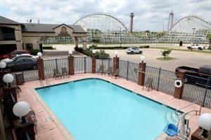 a large swimming pool with a roller coaster in the background at Ranger Inn & Suites in Arlington