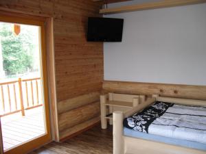 a bedroom with a bed with a television and a balcony at Penzion U Fábů in Lednice