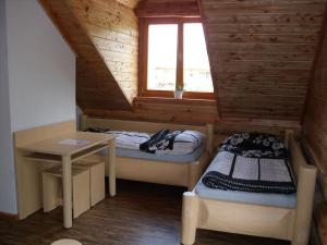 a room with two beds and a table and a window at Penzion U Fábů in Lednice