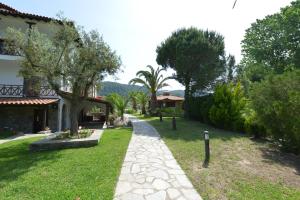a garden with a walkway next to a house at Haus Katerina in Vourvourou