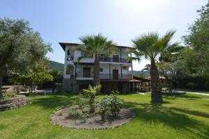 a large house with palm trees in the yard at Haus Katerina in Vourvourou