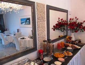 a table with food and a mirror in a room at Pebble Stone House Bed & Breakfast in Swakopmund +30 photos