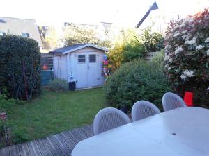 uma mesa e cadeiras num quintal com um barracão em maison individuelle mr Alaphilippe em Vannes