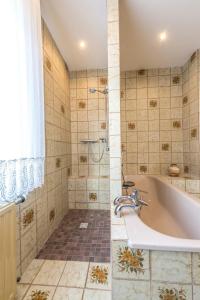 un baño con bañera y ducha en Ferienwohnung Familie Bauer, en Rimlingen