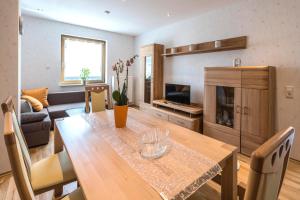 Sala de estar con mesa de comedor y TV en Ferienwohnung Familie Bauer, en Rimlingen