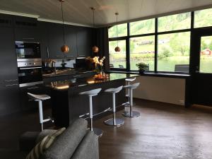 a kitchen with a island with bar stools and windows at Olden apartments 1 in Olden