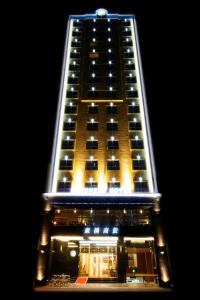 a tall building with lights on it at night at Kindness Hotel - Kaohsiung Guang Rong Pier in Kaohsiung