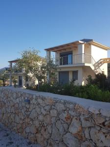 a house on the hill with a stone wall at Luxurious villa at a unique spot in Agios Nikolaos