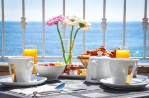 Ein Tisch mit Frühstücksspeisen und Blick auf das Meer in der Unterkunft Torremare in Marine du Miomo