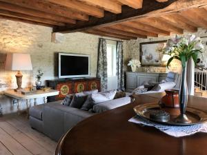 una sala de estar con un sofá y una mesa en La Ferme Blanche, en Cussay