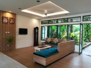 a living room with a couch and a tv at The Greenery Hotel in Krabi town