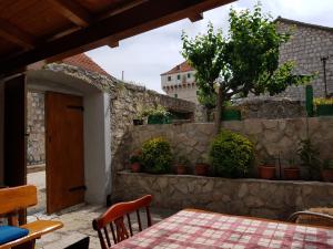 um pátio com uma mesa e uma parede de pedra em Apartment Mirjana em Marina