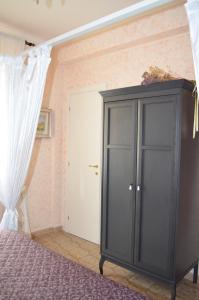 タルクイーニアにあるB&B Nonna Luisaの黒いキャビネットとベッド付きのベッドルーム1室