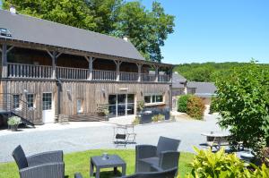 a building with chairs and a table in front of it at Gîte de la Cour in Campandré-Valcongrain