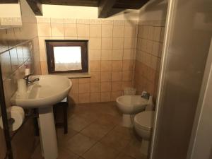 a bathroom with two sinks and a toilet and a window at La Piccola Pizzo in Pizzo
