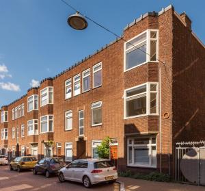 a brick building with cars parked in front of it at Hiltje - Nice to stay in Dordrecht