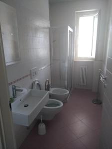 トルトレート・リドにあるResidenza il Grecaleのバスルーム(洗面台2台、トイレ付)、窓が備わります。