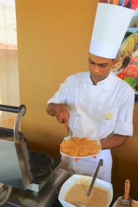 a man in a chef's outfit preparing food in a kitchen at Laya Safari Resorts & Spa in Yala