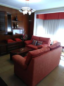 ウベダにあるExcelente apartamento 3 habのリビングルーム(赤いソファ、テーブル付)