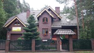 una casa con una recinzione nera davanti di Lesna Polana a Augustów