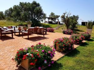 a patio with benches and flowers in a park at Terre Di Vendicari in Noto