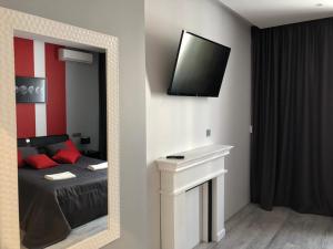 um quarto com uma cama e uma televisão na parede em Bon apetit apartament em Lviv