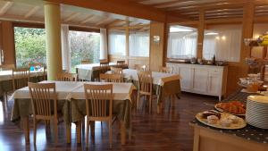 a dining room with tables and chairs in a kitchen at Affittacamere Villa Belfiore in Ronzone
