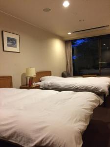 ein Hotelzimmer mit 2 Betten und einem Fenster in der Unterkunft Hotel Park in Gifu