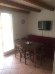 a dining room with a table and chairs and a television at Appartamento La Valle in Marina Romea