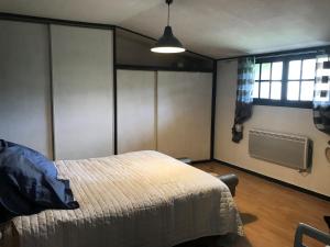 1 dormitorio con cama, ventana y ventana en Maison LES BLEUETS, en Le Perréon