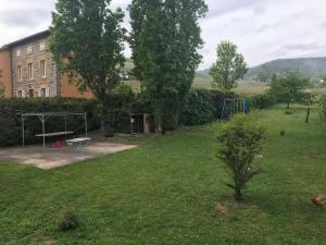 a yard with a park with a playground and a building at Maison LES BLEUETS in Le Perréon