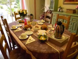 a dining room table with a table set with food at Le Logis d'ANTIGNY in Val-du-Mignon
