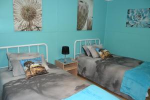 Kallabaskop Eco lodge في Soebatsfontein: سريرين في غرفة بجدران زرقاء