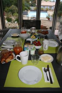 una mesa con platos de comida encima en Mas des Petits Loups B&B, en Cabrières