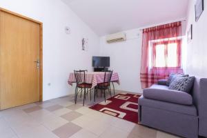ein Wohnzimmer mit einem Sofa und einem Tisch in der Unterkunft Apartments Goga in Mali Lošinj