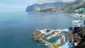une île dans l'océan avec un navire de croisière dans l'établissement Jardins Piornais Funchal Apartment, à Funchal
