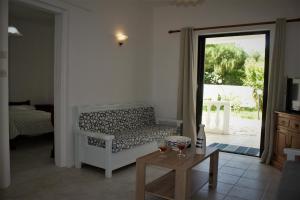 een woonkamer met een bank en 2 glazen wijn bij Rodis Studios in Tsilivi