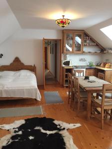 1 dormitorio con cama, mesa y cocina en Nyerges Lovasudvar, en Cserépfalu