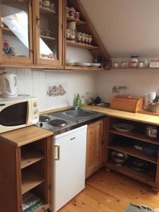 a kitchen with a microwave and a stove top oven at Nyerges Lovasudvar in Cserépfalu +7 photos