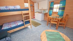 a small room with a bunk bed and a table at Hytte Camp Nordkapp - Blue in Skarsvåg