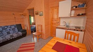 a kitchen and a living room in a log cabin at Hytte Camp Nordkapp - Blue in Skarsvåg +34 photos