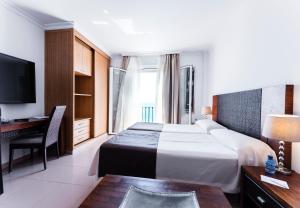 a hotel room with a bed and a desk at Toboso Apar - Turis in Nerja +37 photos
